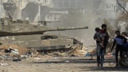 Palestinians flee Gaza City as an Israeli armoured vehicle rolls past
