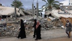 Palestinians walk past destroyed houses in Khuzaa, near Khan Yunis