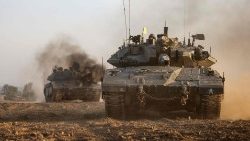 Israeli military tanks roll near the border with Gaza amid continuing battles