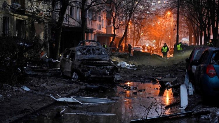 Esta fotografia tirada em 13 de dezembro de 2023 mostra carros destruídos próximos a um prédio residencial danificado após um ataque de míssil em Kiev. (Foto de SERGEI CHUZAVKOV/AFP)