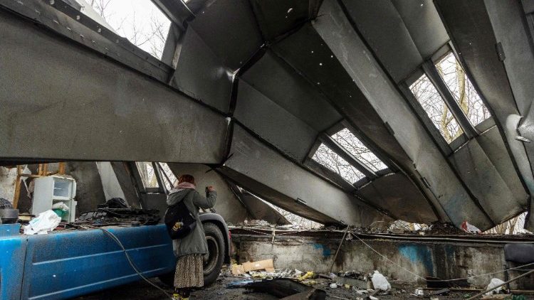 Uma mulher inspeciona uma oficina municipal de reparos de automóveis danificada como resultado de um ataque de drone em Odesa em 13 de dezembro de 2023, em meio à invasão russa da Ucrânia. (Foto de Oleksandr GIMANOV/AFP)
