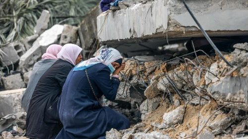 Mulheres em lágrimas em Gaza, diante dos escombros causados por bombardeios (AFP)
