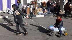Ein Junge zieht in Rafah im südlichen Gazastreifen an diesem Freitag ein anderes Kind mit einem Sack Lebensmittel auf einem kleinen Wagen über die Straße