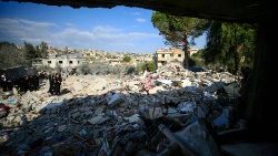 אנשים בודקים את הריסות הבניין בבינת ג'בייל בדרום לבנון ליד הגבול עם ישראל, לאחר הפצצה ישראלית בלילה הקודם ב-27 בדצמבר