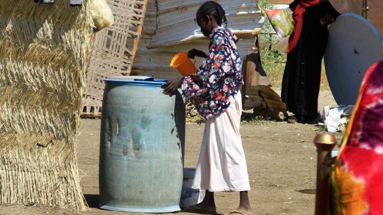 A displaced girl in Sudan's Jazira state fetches water at a temporary shelter in Gedaref in the east of the country
