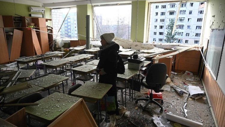 Professora olha danos em sala de aula atingida por míssil russo em Lviv, em 29 de dezembro de 2023. (Photo by Yuriy Dyachyshyn/AFP)