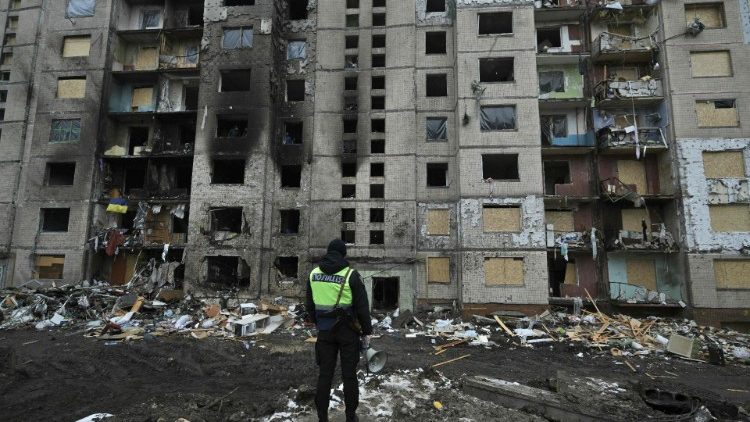 Um policial está em frente a um prédio residencial fortemente danificado, três dias após um ataque com mísseis russos em Kiev, em 5 de janeiro de 2024. (Photo by Genya SAVILOV / AFP)