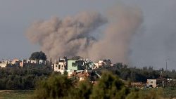 Un'immagine scattata da una postazione in Israele, lungo il confine con la Striscia di Gaza, mostra il fumo che fuoriesce dagli edifici bombardati (AFP)