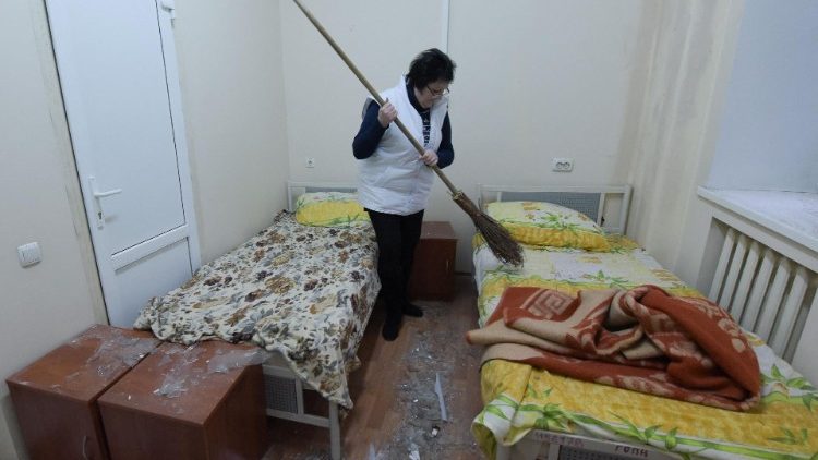 Uma mulher varre os vidros das janelas quebradas das camas em uma enfermaria de hospital danificada como resultado de um bombardeio em Donetsk, na Ucrânia controlada pela Rússia, em 7 de janeiro de 2024, em meio ao conflito russo-ucraniano em curso. (Foto de STRINGER/AFP)