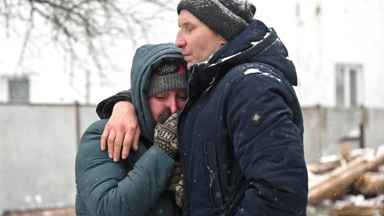Reação de moradores locais próximo ao local atingido por mísseis russos em Zmiiv, região de Kharkiv, em 8 de janeiro de 2024. (Foto de SERGEY BOBOK/AFP)