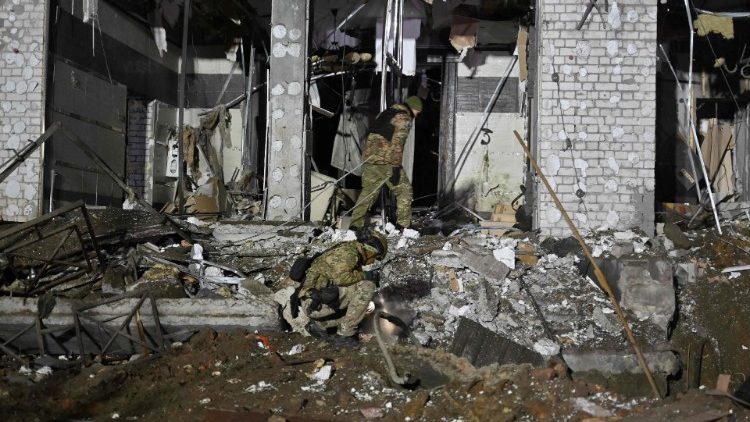 Especialistas em explosivos militares ucranianos examinam o local de um hotel destruído após um ataque com mísseis em Kharkiv, em 11 de janeiro de 2024, em meio à invasão russa da Ucrânia. (Foto de SERGEY BOBOK/AFP)