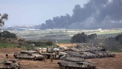 Israeli soldiers and tanks sit near the border with the Gaza Strip