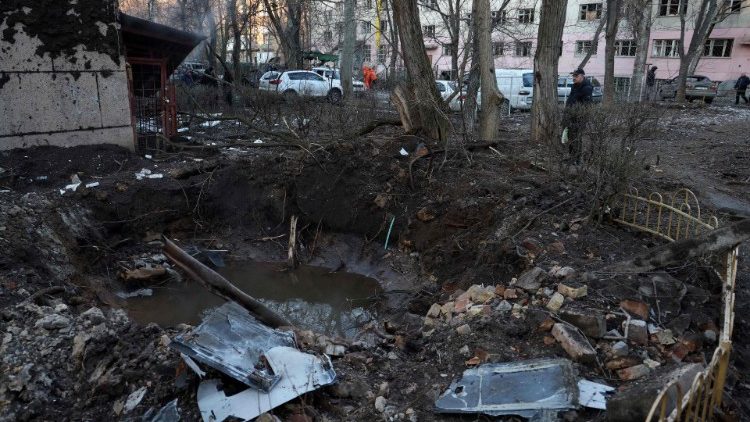 Um homem está ao lado de uma cratera no pátio de um edifício residencial danificado após um ataque de drone em Odessa em 17 de janeiro de 2024. (Foto de Oleksandr GIMANOV/AFP)
