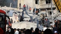 Security and emergency personnel search the rubble of a building destroyed in a strike on Damascus