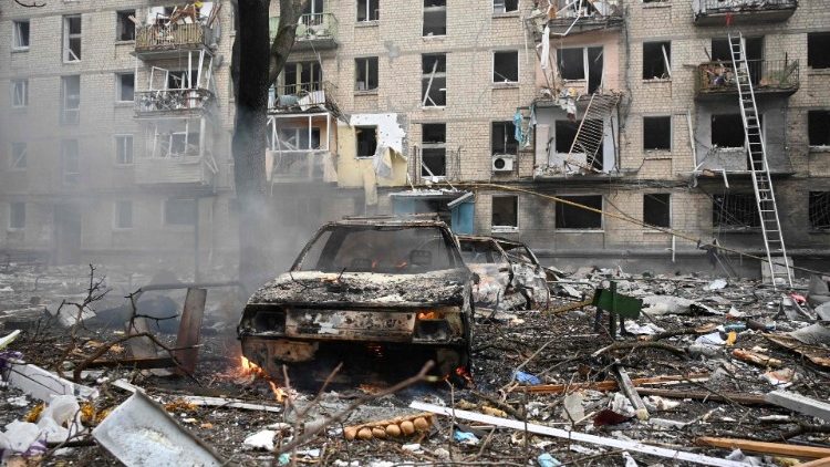 Esta fotografia tirada em 23 de janeiro de 2024 mostra veículos destruídos em frente a um edifício residencial destruído como resultado de um ataque de mísseis em Kharkiv. Dezenas de pessoas ficaram feridas e duas mortas após uma barragem aérea noturna das forças russas visando a capital ucraniana, Kiev, e a segunda maior cidade, Kharkiv, disseram autoridades em 23 de janeiro de 2024. (Foto de SERGEY BOBOK / AFP