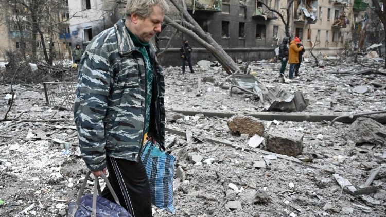 Um residente local caminha sobre os escombros em frente a um edifício residencial danificado como resultado de um ataque de mísseis em Kharkiv em 23 de janeiro de 2024. Dezenas de pessoas ficaram feridas e duas mortas após uma barragem aérea noturna das forças russas visando a capital ucraniana Kiev e a segunda maior cidade de Kharkiv, disseram autoridades em 23 de janeiro de 2024. (Foto de SERGEY BOBOK / AFP)