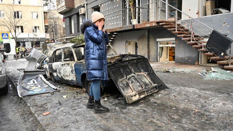 Mulher chora do lado de fora de um prédio danificado em Kharkiv, em 24 de janeiro de 2024, um dia depois de uma barragem de mísseis russos em todo o país. (Foto de SERGEY BOBOK/AFP)