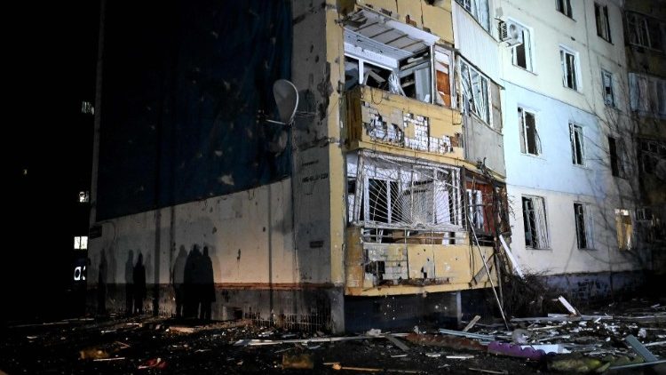 Sombras de pessoas são vistas na parede de um edifício residencial danificado como resultado de um ataque de drone em Kharkiv no início de 31 de janeiro de 2024. (Foto de SERGEY BOBOK / AFP)