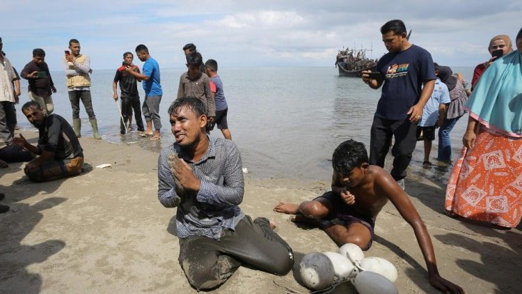 Refugiados Rohingya recém-chegados reagem depois de chegar à praia nadando enquanto outros ficam presos em um barco depois que a comunidade próxima decidiu não permitir que desembarcassem, mas lhes deu água e comida em Pineung, província de Aceh, em 16 de novembro de 2023. (Photo by AMANDA JUFRIAN / AFP) 