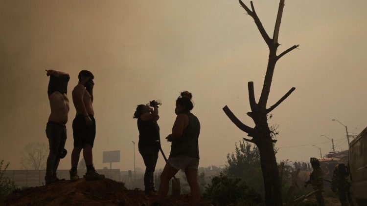 Residents in Quilpe, Chile help firefighters battle a forest fire