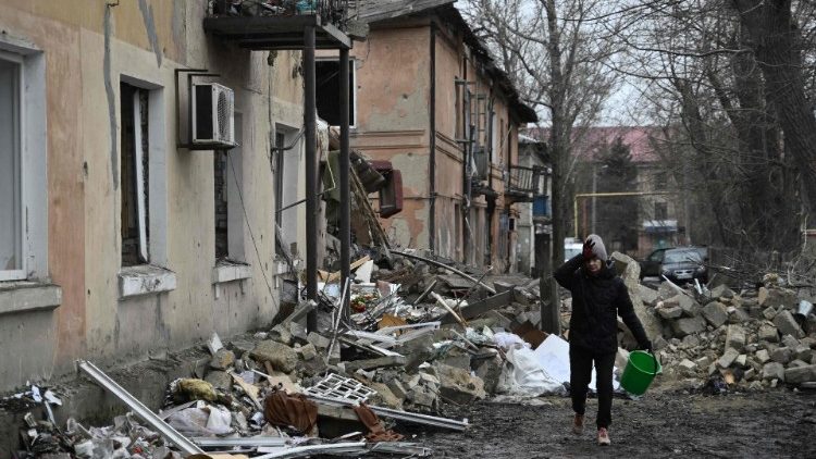 Uma mulher passa por um prédio  residencial danificado por um ataque de mísseis na cidade de Selydove, região de Donetsk, em 8 de fevereiro de 2024, em meio à invasão russa da Ucrânia. (Foto de Genya SAVILOV/AFP)