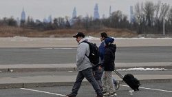 Des migrants récemment arrivés aux États-Unis se rendent à un arrêt de bus devant le refuge Flyod Bennett Field, le 21 février 2024, dans le quartier de Brooklyn à New York. 