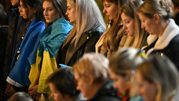 אנשים מתפללים למען השלום באוקראינה במהלך תפילה בין-דתית בקתדרלה הקתולית האוקראינית של המשפחה הקדושה בלונדון