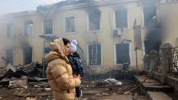 Una mamma con il suo bambino in una città ucraina bombardata