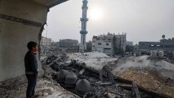 Un bambino difronte un edificio distrutto dai bombardamenti a Rafah 