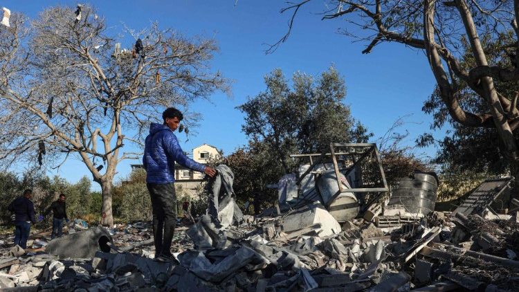 Palestinos procurando por seus pertences após um bombardeio em Rafah 