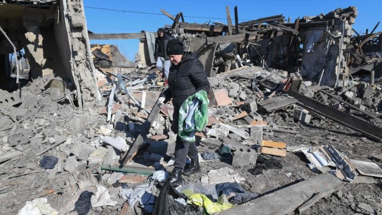 Moradores locais limpam os escombros de casas em ruínas após o bombardeio no assentamento de Hanzhenkova, nos arredores de Makiivka (Makeyevka), Ucrânia controlada pela Rússia, em meio ao conflito Rússia-Ucrânia em 12 de março de 2024. (Foto de STRINGER / AFP)