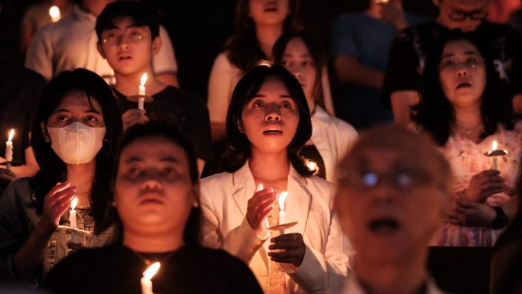 Des fidèles catholiques tiennent des bougies lors de la veillée pascale à Jakarta (30 mars 2024)