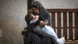 A woman holds her child in Gaza
