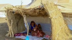 A displaced woman and her children at a camp in southern Gadaref state