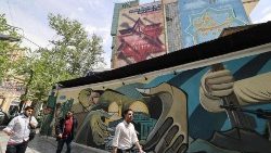 Iranians walk next to an anti-Israel poster in Tehran on 13 April.