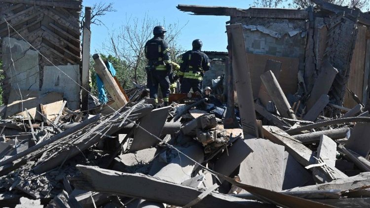Пажарнікі на развалінах жылога дома ў Харкаве, разбуранага ў выніку расійскай бамбардзіроўкі