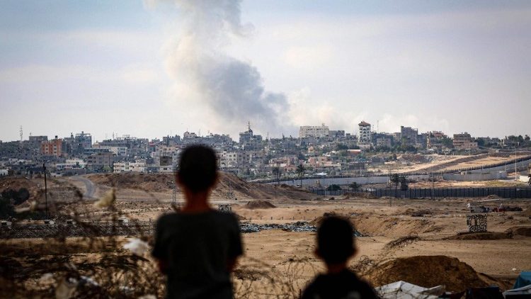 Unos niños observan el humo que se desprende durante los ataques israelíes al este de Rafah, en el sur de la Franja de Gaza, el 13 de mayo de 2024 (AFP)