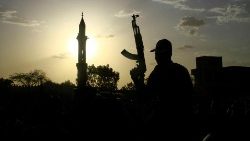 Un militaire lève son arme au Soudan.