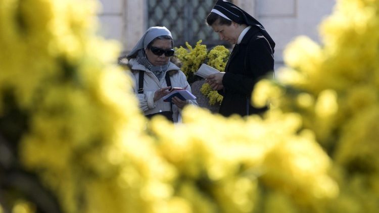 Ordensfrauen vor Mimosen, den Blumen, die in Italien klassischerweise zum Weltfrauentag verschenkt werden