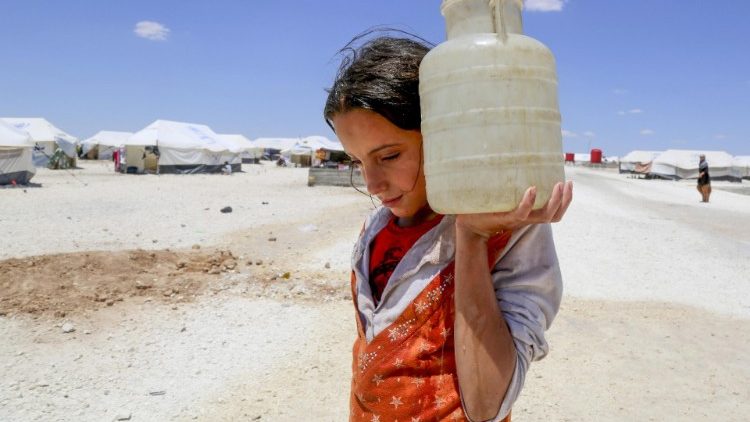 A young woman carries a jug of water