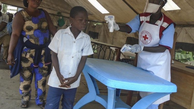 Agentes da Cruz Vermelha Uganfa medem a temperatura da população em Mpondwe, oeste do país