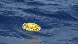 Una corona di fiori, omaggio per i migranti morti in mare