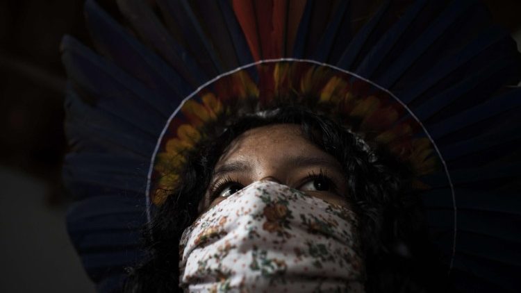 Indígena perteneciente a la Amazonia brasileña se protege del coronavirus con una mascarilla.