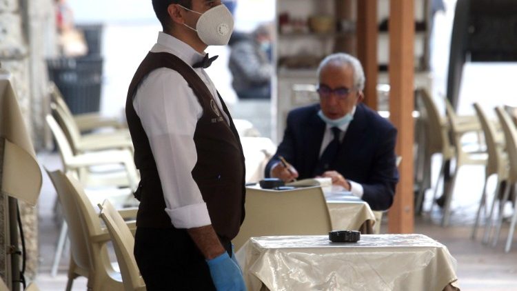 Un cameriere con la mascherina in un bar di Milano dopo la riapertura (Ansa/Matteo Bazzi)
