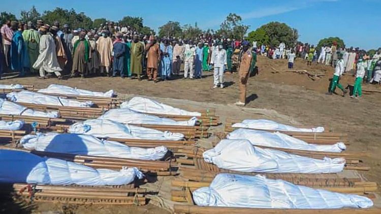 Nigerian mourners attend the mass burial of farm workers killed in an attack at Zabarmari, Borno State