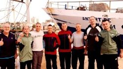 In Libyen entführte italienische Fischer, die wieder freigelassen wurden, posieren vor ihrem Fischerboot in Bengasi