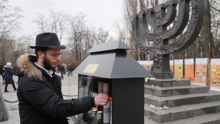 A man lights a candle during a ceremony marking Holocaust Remembrance Day 