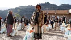 Des yéménites reçoivent des rations alimentaires fournies par le groupe d'aide local, mona relief yemen, dans un centre de distribution situé dans le village de montagne de Bani al-Qallam, à quelque 100 km au sud-ouest de Sanaa, au Yémen, le 13 février 2021. 