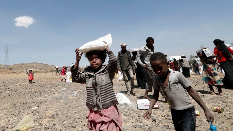 Niños en Yemen recogiendo comida repartida por ONGs.