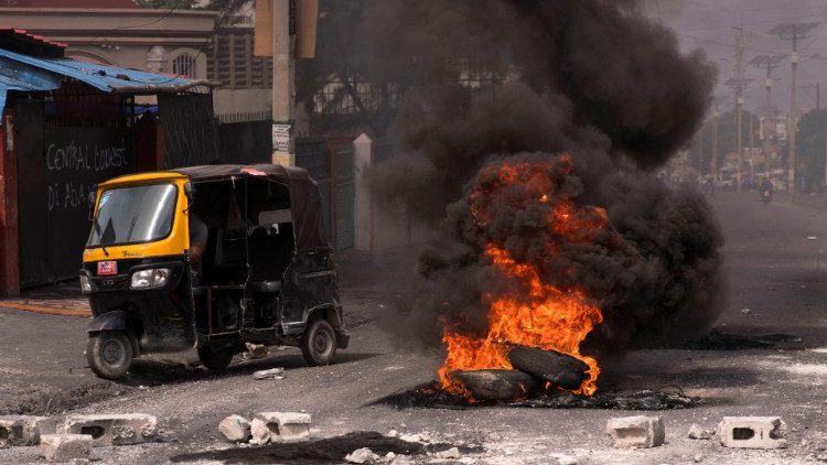 A monotaxi passes burning barricades in Port-au-Prince during protests earlier this month